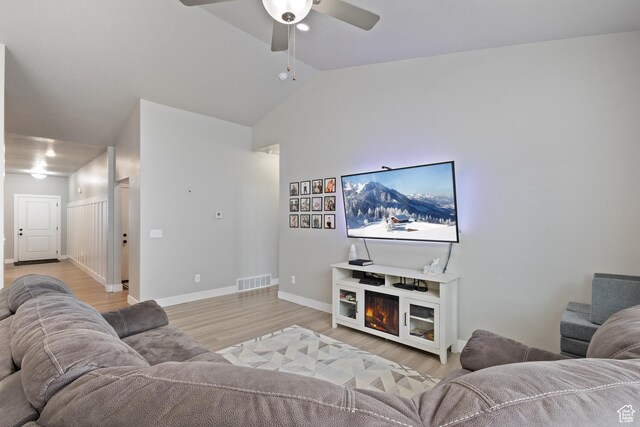 4142 N Fairfield Dr, Eagle Mountain, UT 84005 - living room with lofted ceiling, light wood-style flooring, a fireplace, visible vents, and a ceiling fan