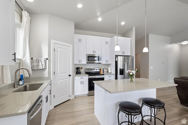 4142 N Fairfield Dr, Eagle Mountain, UT 84005 - kitchen with a center island, a breakfast bar area, stainless steel appliances, white cabinets, and a sink
