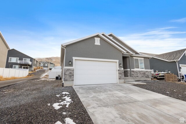 4142 N Fairfield Dr, Eagle Mountain, UT 84005 - view of front of home with stucco siding, concrete driveway, an attached garage, fence, and stone siding
