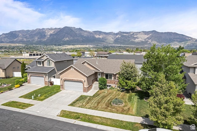 view of front of home with a mountain view, stucco siding, a residential view, a shingled roof, and concrete driveway
