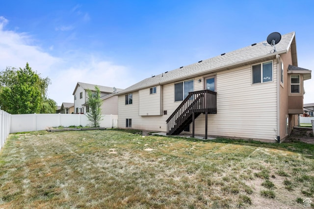 rear view of property with a yard, stairs, and a fenced backyard
