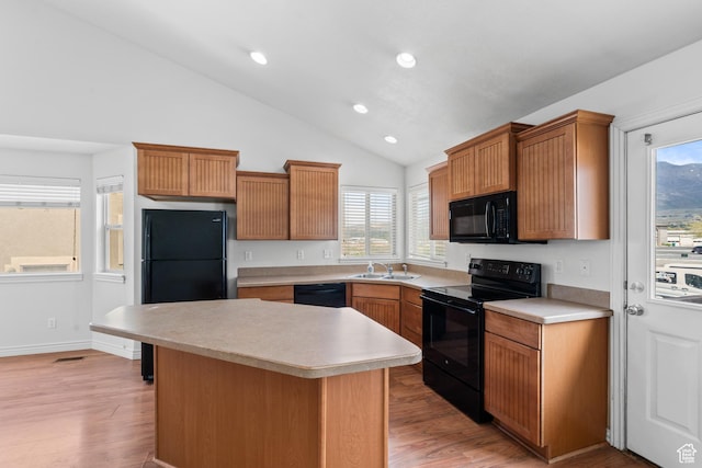 kitchen featuring light countertops, a wealth of natural light, lofted ceiling, and black appliances