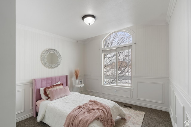 carpeted bedroom featuring multiple windows and a decorative wall