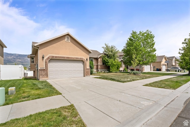 ranch-style house featuring fence, a garage, stucco siding, concrete driveway, and a front yard