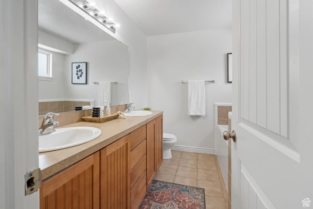 bathroom with toilet, tile patterned floors, double vanity, and a sink