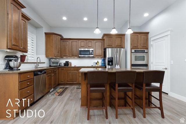 3013 W Alta Peak Rd, South Jordan, UT 84095 - kitchen with stainless steel appliances, a kitchen island, brown cabinets, dark stone countertops, and pendant lighting