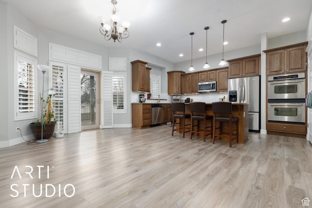 3013 W Alta Peak Rd, South Jordan, UT 84095 - kitchen with appliances with stainless steel finishes, a breakfast bar area, a center island, hanging light fixtures, and light wood-style floors