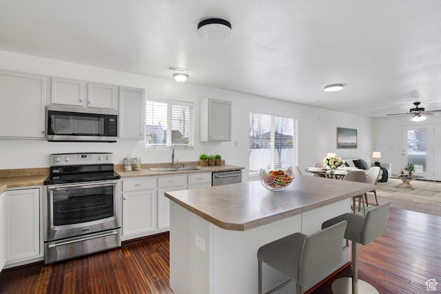 298 Beaumont Dr, Kaysville, UT 84037 - kitchen with stainless steel appliances, a sink, a kitchen bar, open floor plan, and plenty of natural light
