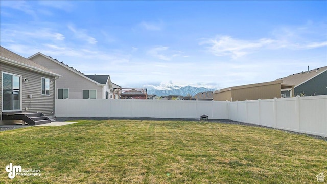 view of yard featuring a fenced backyard and a mountain view