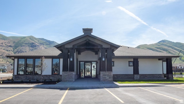 view of property with uncovered parking and a mountain view