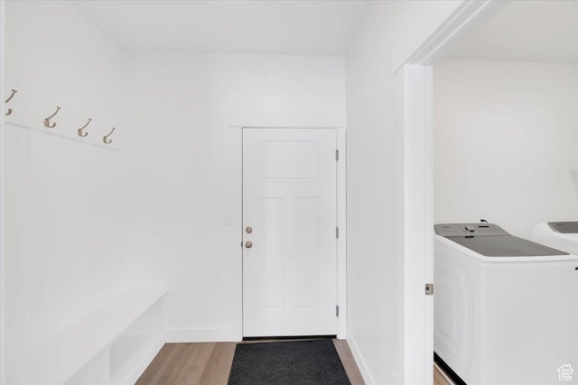 washroom with independent washer and dryer, laundry area, and light wood-type flooring
