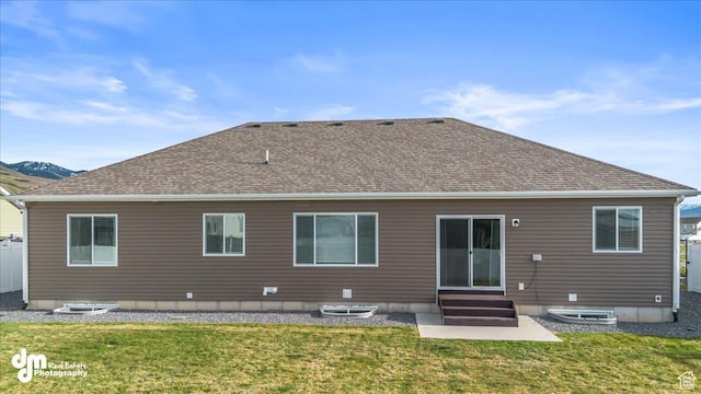back of property featuring a yard, roof with shingles, and entry steps
