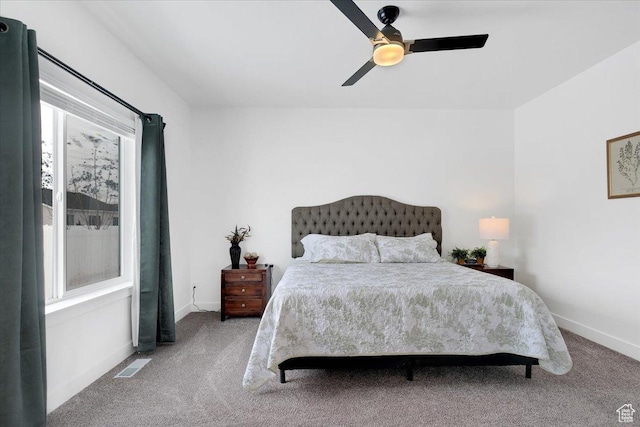 carpeted bedroom with baseboards, visible vents, and ceiling fan