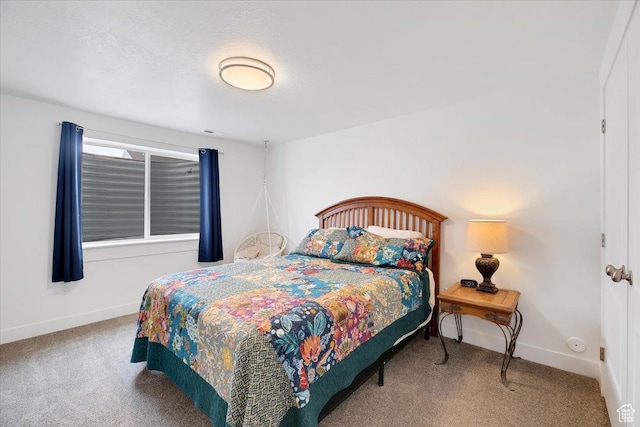 bedroom with baseboards and carpet