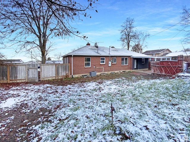2943 S 400 W, Bountiful, UT 84010 - snow covered rear of property with brick siding, fence, a gate, and central air condition unit