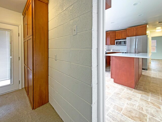 2943 S 400 W, Bountiful, UT 84010 - interior space featuring a kitchen island, light countertops, appliances with stainless steel finishes, brown cabinets, and a kitchen bar