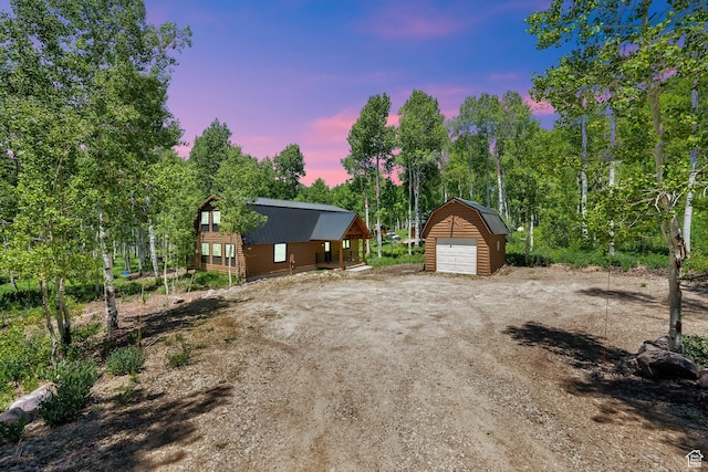11249 E Columbine Ln Unit 1607, Heber City, UT 84032 - property exterior at dusk featuring a garage, an outbuilding, and view of wooded area