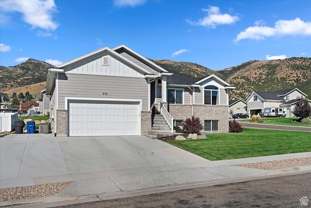 912 N 600 E, Morgan, UT 84050 - view of front of house with board and batten siding, a front lawn, a mountain view, and an attached garage
