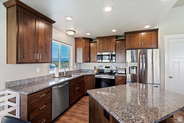 912 N 600 E, Morgan, UT 84050 - kitchen featuring wood finished floors, a center island, stainless steel appliances, stone counters, and a sink