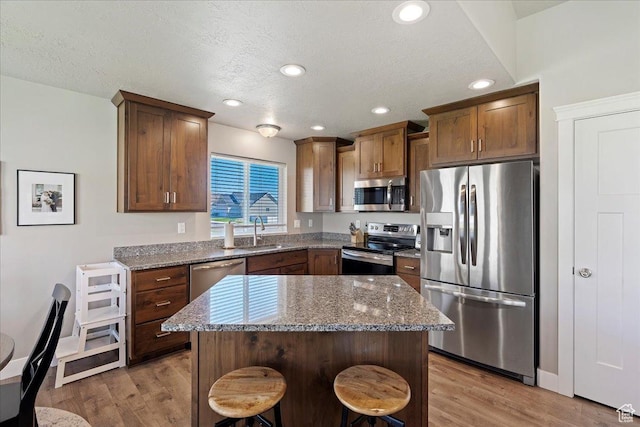 912 N 600 E, Morgan, UT 84050 - kitchen featuring stainless steel appliances, a kitchen island, a sink, dark stone counters, and a kitchen breakfast bar