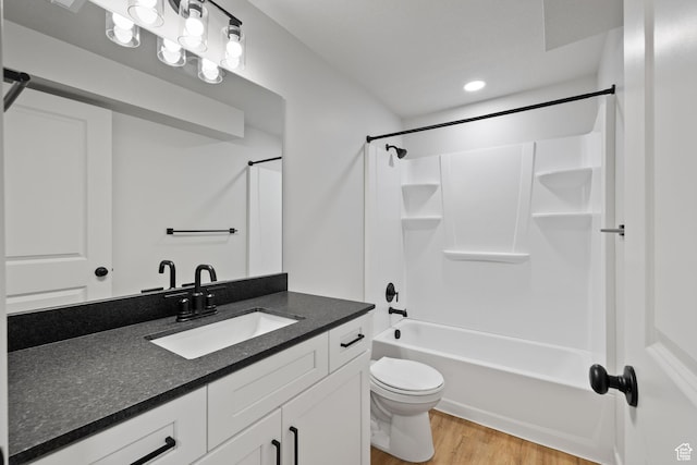 bathroom with vanity, shower / bathing tub combination, wood finished floors, and toilet
