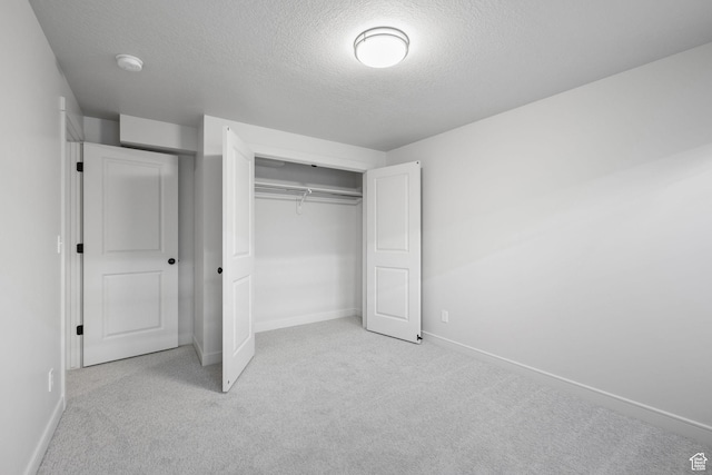 unfurnished bedroom featuring baseboards, a closet, and carpet flooring