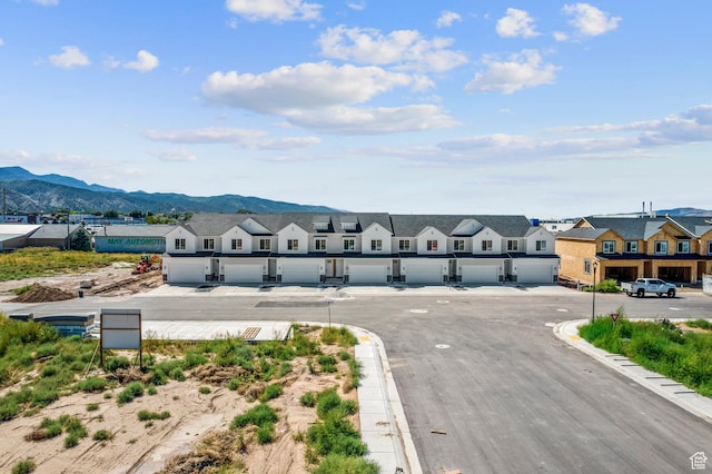 view of street with a residential view, a mountain view, and curbs