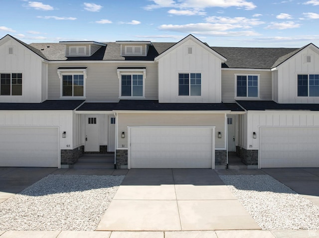 view of front facade with an attached garage, concrete driveway, stone siding, roof with shingles, and board and batten siding