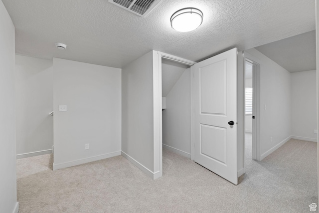 bonus room featuring light carpet, baseboards, visible vents, and a textured ceiling