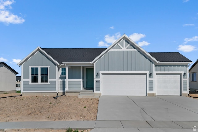2571 N 3200 W, Clinton, UT 84015 - view of front of house featuring board and batten siding, a garage, driveway, and roof with shingles