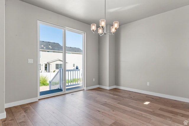 2571 N 3200 W, Clinton, UT 84015 - spare room featuring a chandelier, light wood-style flooring, and baseboards