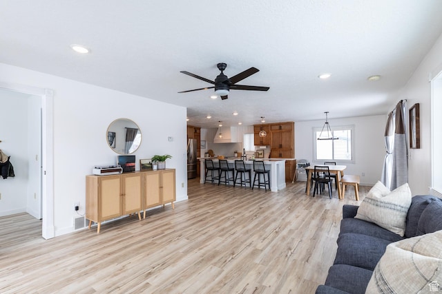 living room with light wood-type flooring, baseboards, and recessed lighting