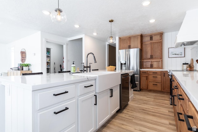 93 N 200 W, Smithfield, UT 84335 - kitchen with a large island, hanging light fixtures, light wood-style flooring, white cabinetry, and premium range hood