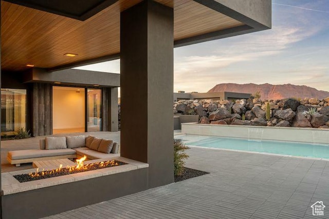 2655 W Shoshoni Trl, St George, UT 84770 - pool at dusk featuring an outdoor fire pit, an outdoor pool, a patio, and a mountain view