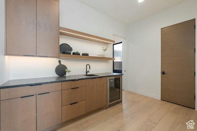 2655 W Shoshoni Trl, St George, UT 84770 - bar with wine cooler, indoor wet bar, light wood-style flooring, a sink, and baseboards