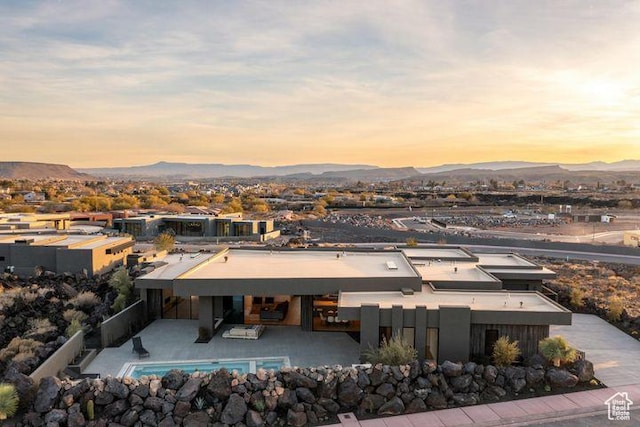 2655 W Shoshoni Trl, St George, UT 84770 - back of house at dusk with fence, a mountain view, and a patio