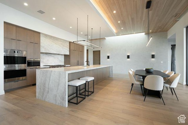 2655 W Shoshoni Trl, St George, UT 84770 - kitchen featuring light countertops, hanging light fixtures, visible vents, modern cabinets, and a large island with sink