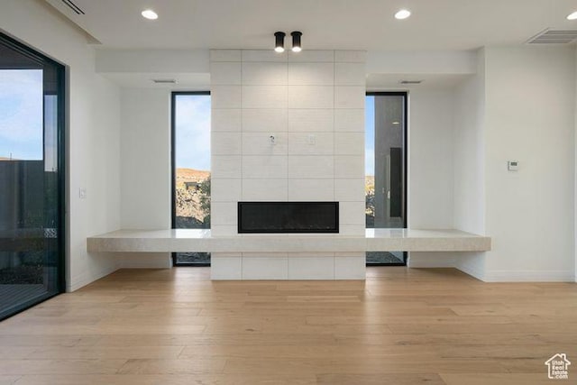 2655 W Shoshoni Trl, St George, UT 84770 - unfurnished living room featuring recessed lighting, visible vents, light wood-style flooring, and a tiled fireplace