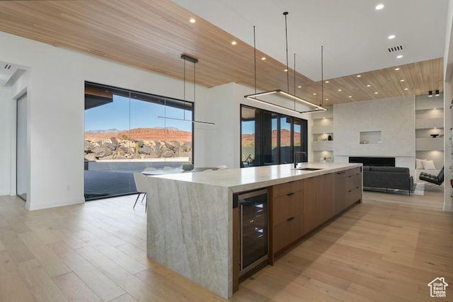 2655 W Shoshoni Trl, St George, UT 84770 - kitchen with beverage cooler, a large island, modern cabinets, light countertops, and a sink