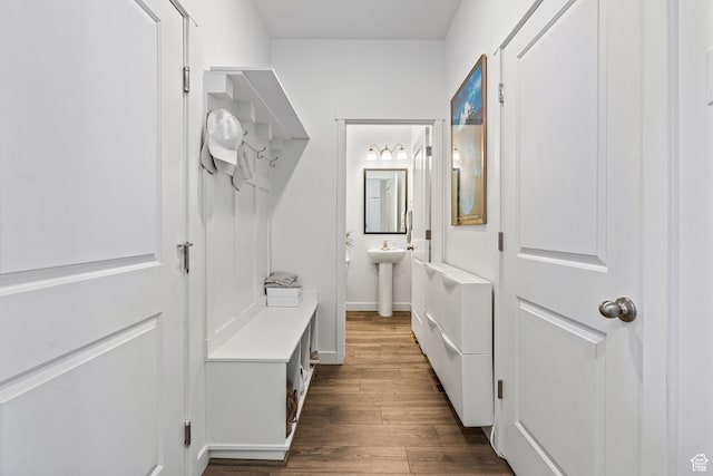 mudroom featuring dark wood-style floors, a sink, and baseboards