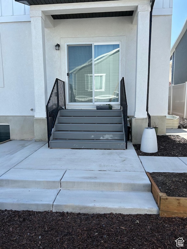 doorway to property featuring stucco siding