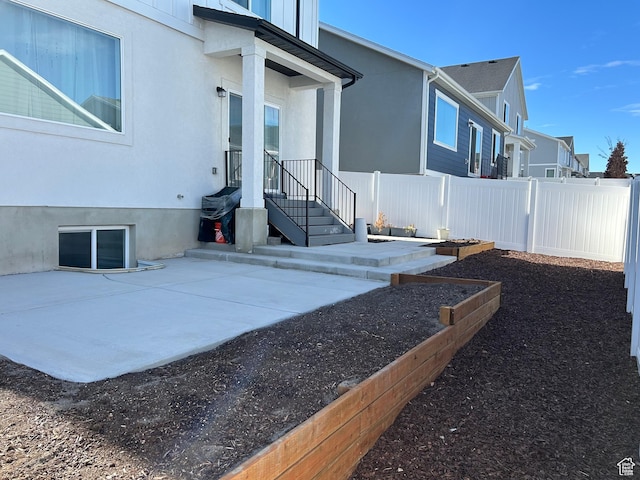 view of property exterior with a garden, fence, and stucco siding