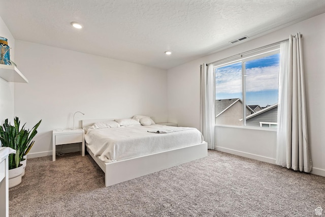 carpeted bedroom with recessed lighting, a textured ceiling, and baseboards
