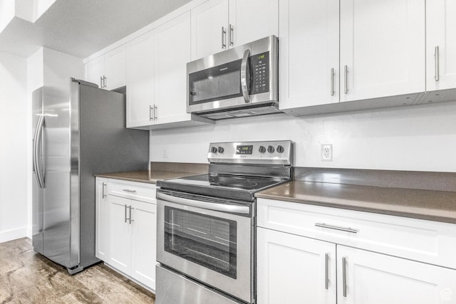 875 S Depot St Unit C316, Clearfield, UT 84015 - kitchen with dark countertops, light wood finished floors, appliances with stainless steel finishes, and white cabinets