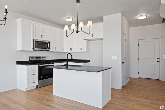 107 W 1360 N, Nephi, UT 84648 - kitchen featuring stainless steel appliances, dark countertops, white cabinetry, a sink, and an island with sink