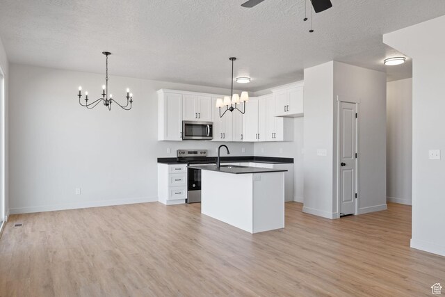 107 W 1360 N, Nephi, UT 84648 - kitchen with a center island with sink, white cabinets, dark countertops, appliances with stainless steel finishes, and decorative light fixtures