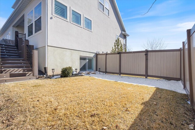 2321 E John Holladay Ct S, Holladay, UT 84117 - view of home's exterior with stucco siding, a fenced backyard, a lawn, and stairs