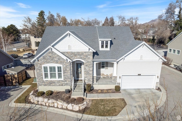 view of front of property featuring a garage, concrete driveway, a shingled roof, and covered porch