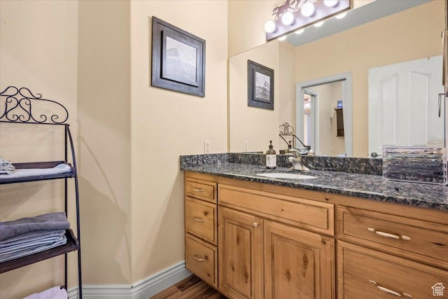bathroom featuring baseboards, vanity, and wood finished floors