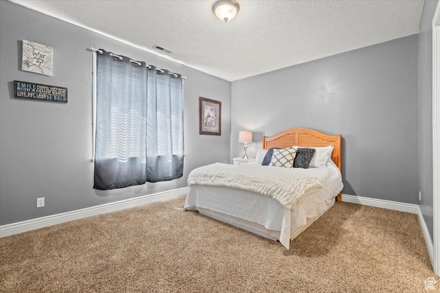 carpeted bedroom with visible vents, baseboards, and a textured ceiling